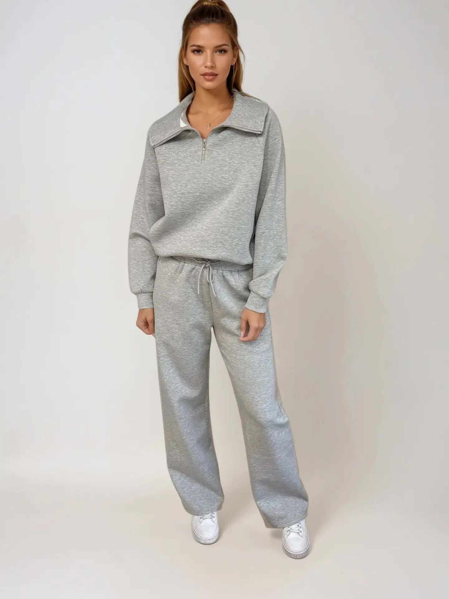 Woman wearing a gray tracksuit on a white background PRIV