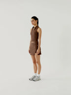 Woman wearing a brown sleeveless top and skirt set on a white background