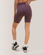Person wearing purple athletic shorts on a light gray background Rose Boreal