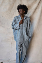 Man wearing a gray textured outfit against a beige fabric background Devlyn van Loon