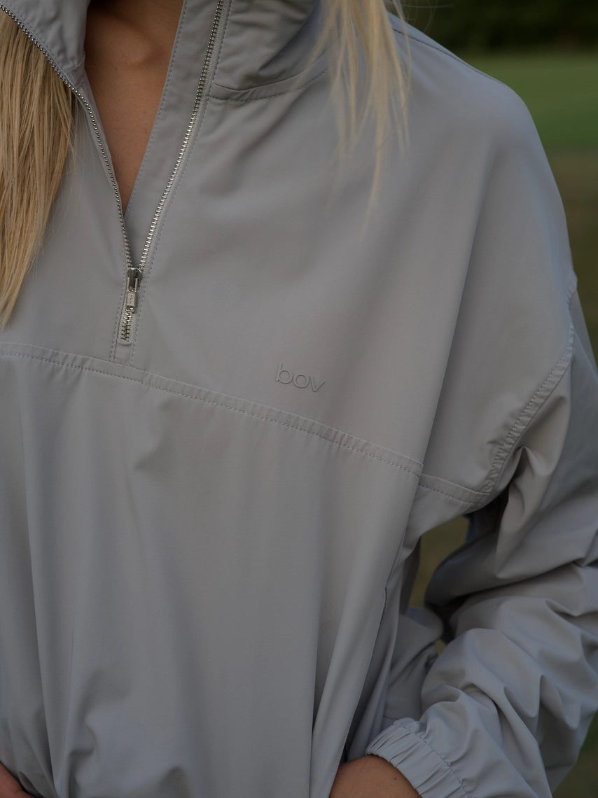Close up of cloud grey BOV Active Mia half zip jacket with silver zipper and BA logo
