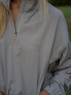 Close up of cloud grey BOV Active Mia half zip jacket with silver zipper and BA logo