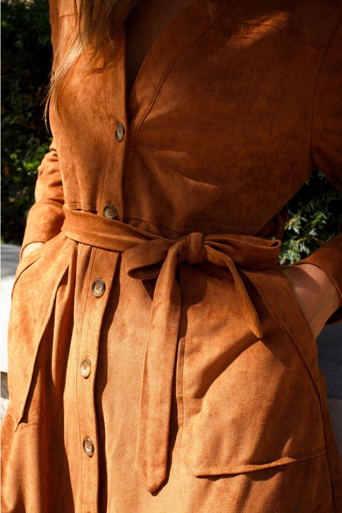 Close-up of a brown suede dress with buttons and a belt. ANNICK
