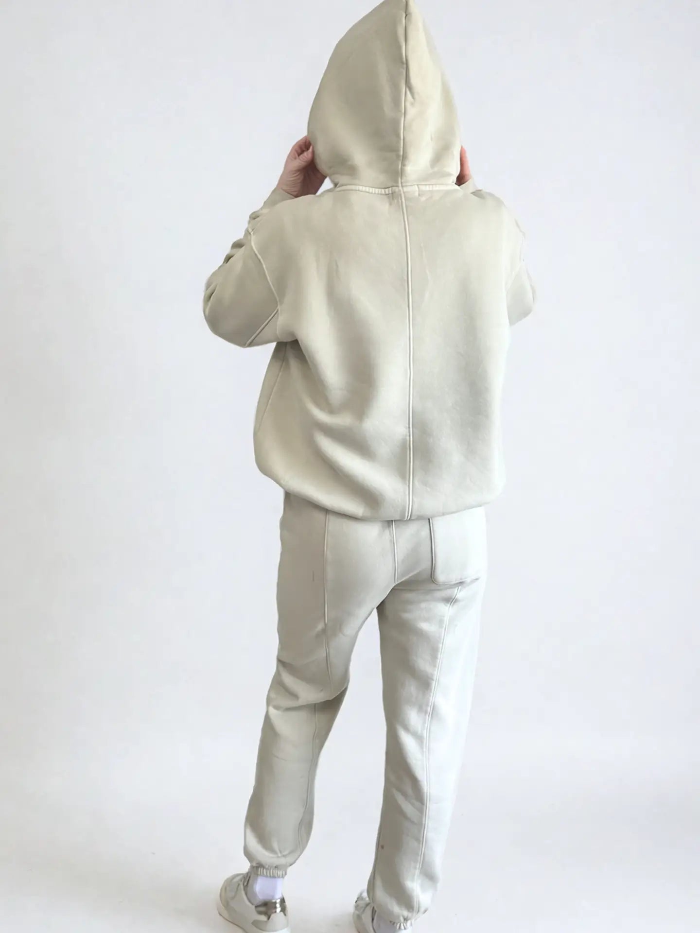 Women wearing a beige hoodie and pants set on a white background PRIV