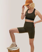 Woman in athletic wear posing on a wooden block against a plain background Rose Boreal