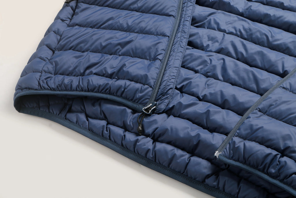 Close-up of a blue puffer jacket on a light beige background Aparso