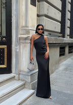 Woman in a black one-shoulder dress standing outside a building. Standpoint Top