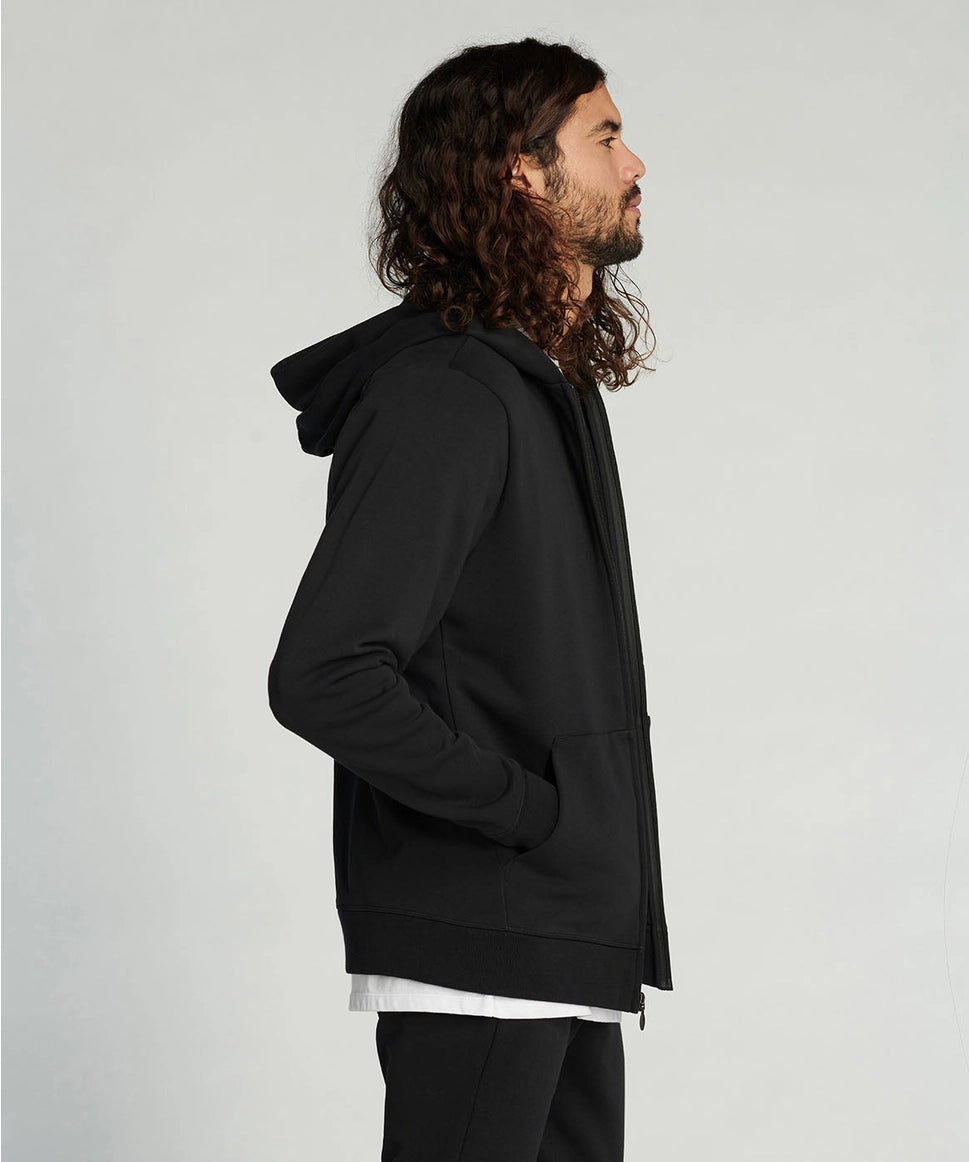 Man wearing a black hoodie against a plain background RYU