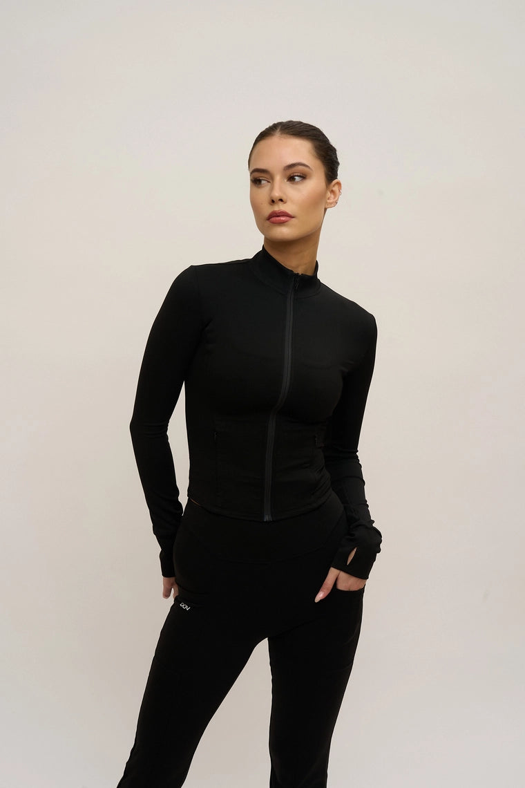 Woman wearing a black outfit against a plain background