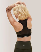 Woman wearing a black sports bra and leggings on a plain background Rose Boreal