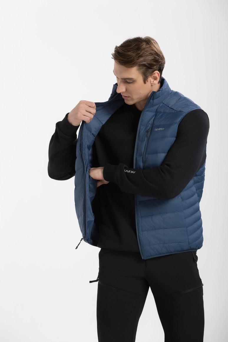 Man wearing a blue puffer vest over a black shirt on a white background Aparso