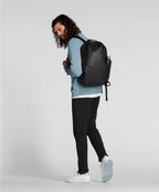 Man wearing a black backpack on a light gray background RYU