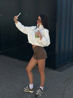 Person taking a selfie outdoors against a black wall