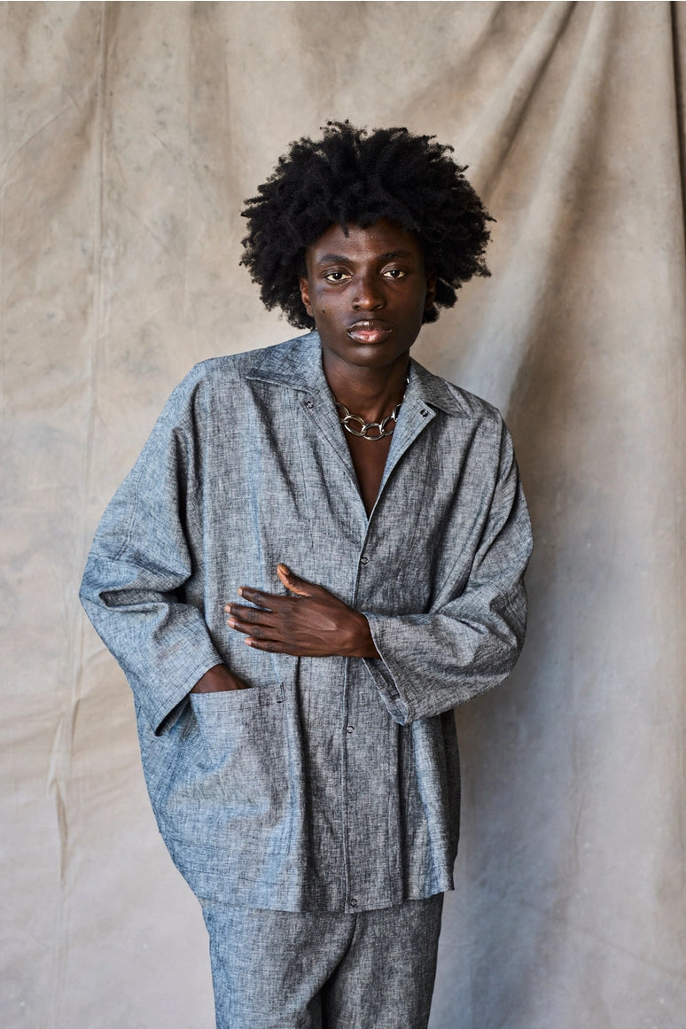 Man wearing a gray suit against a beige curtain background Devlyn van Loon