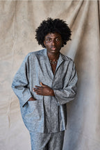 Man wearing a gray suit against a beige curtain background Devlyn van Loon