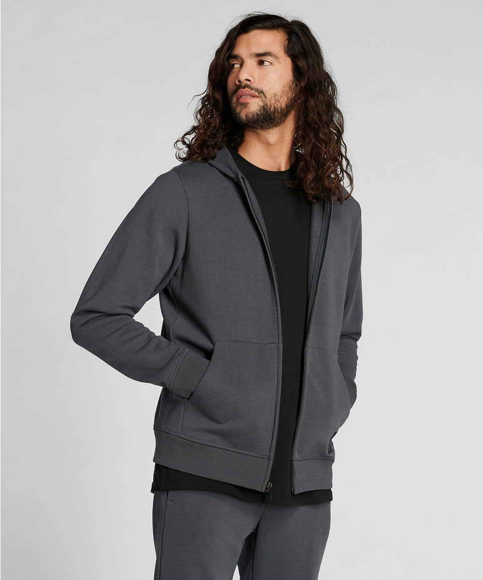 Man wearing a gray hoodie on a light gray background RYU