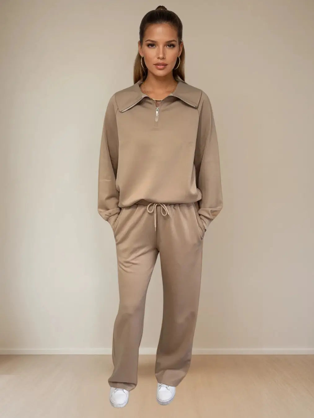 Woman wearing a beige tracksuit against a plain background PRIV