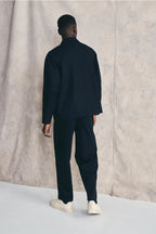 Man wearing a dark blue outfit standing against a neutral background Devlyn van Loon  Devlyn van Loon  