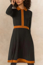 Woman wearing Clarissa knit dress in black with rust orange contrast trim, full length view
