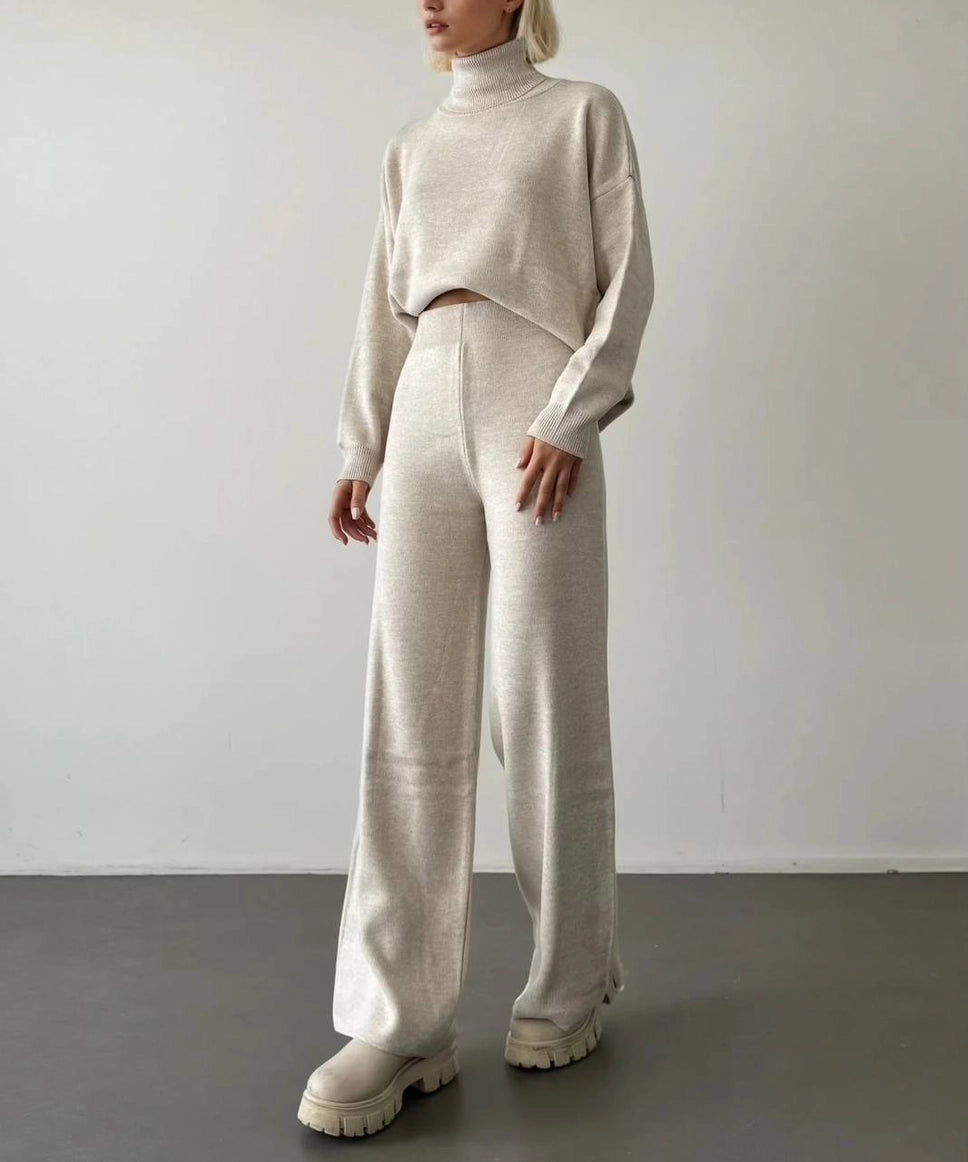 Person wearing a beige knit outfit with wide-leg pants against a plain background Anaz