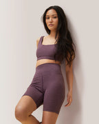 Woman wearing a purple athletic outfit against a plain background Rose Boreal