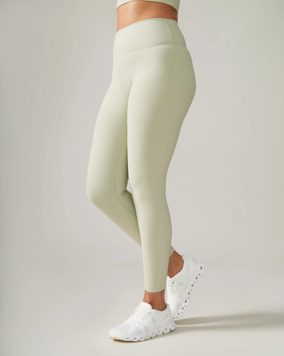 Women wearing light green leggings and white sneakers on a plain background Rose Boreal