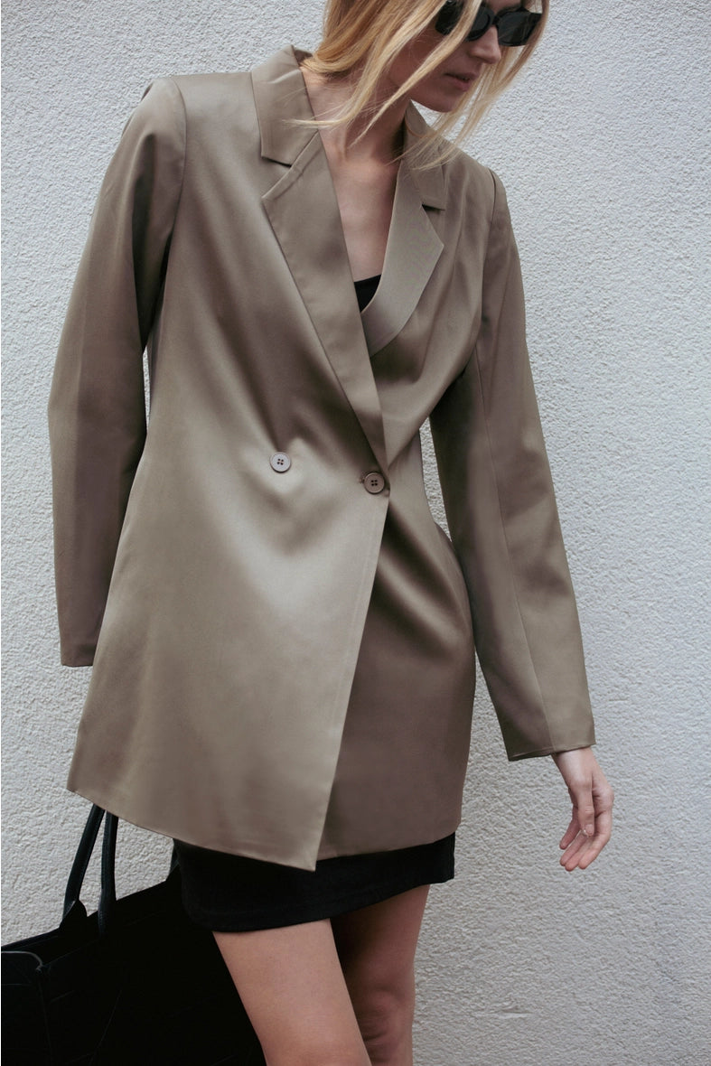Person wearing a beige blazer against a plain background  Amanda Maria