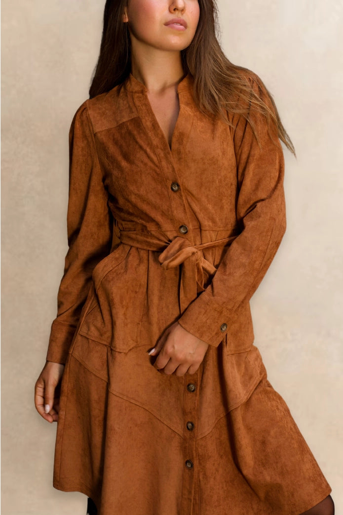 Woman wearing a brown suede dress against a neutral background ANNICK