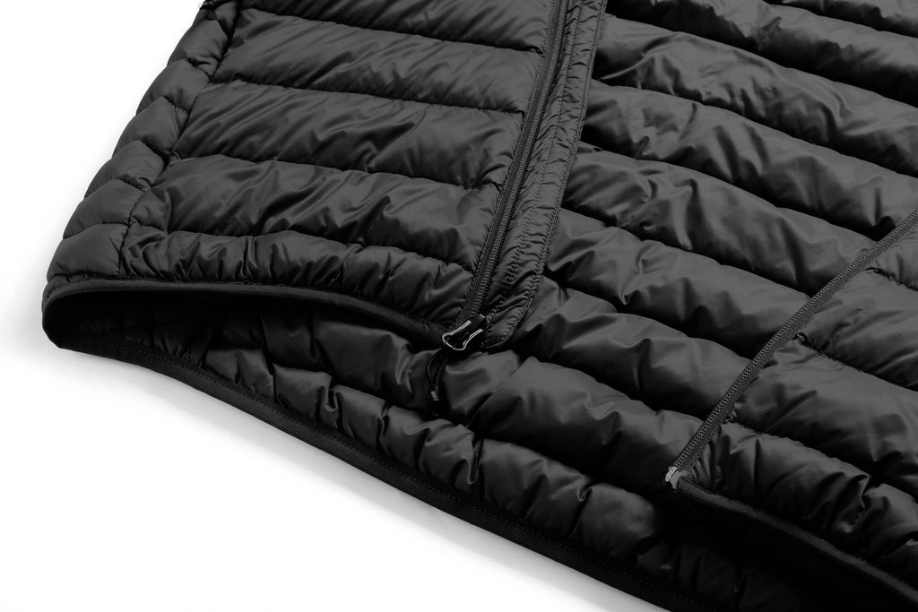 Close-up of a black puffer jacket on a white background Aparso