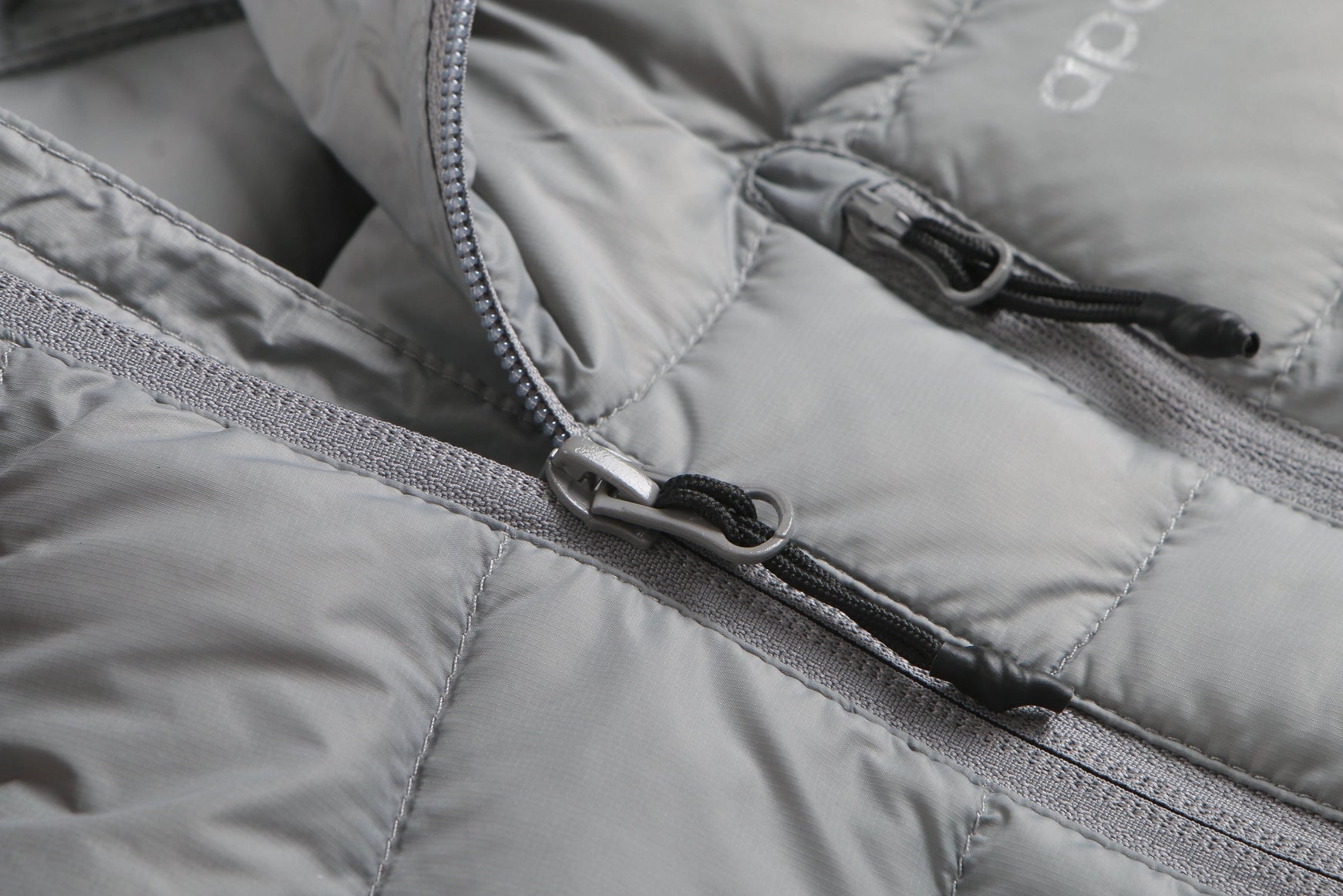 Close-up of a gray puffer jacket with a zipper Aparso