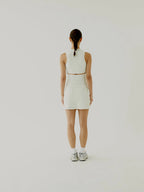 Cream BOVwomen wearing a cream sleeveless top and skirt set on a plain background