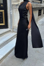 Women wearing a black sleeveless dress with wide-leg pants in an urban setting. Standpoint Top