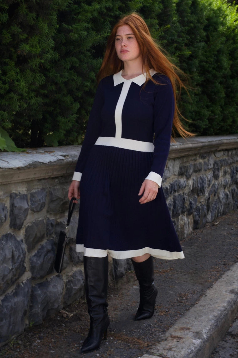 Side view of woman wearing Clarissa knit dress in navy with contrast details
