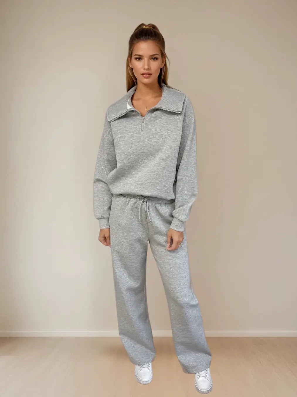 Woman wearing a gray tracksuit against a beige background PRIV