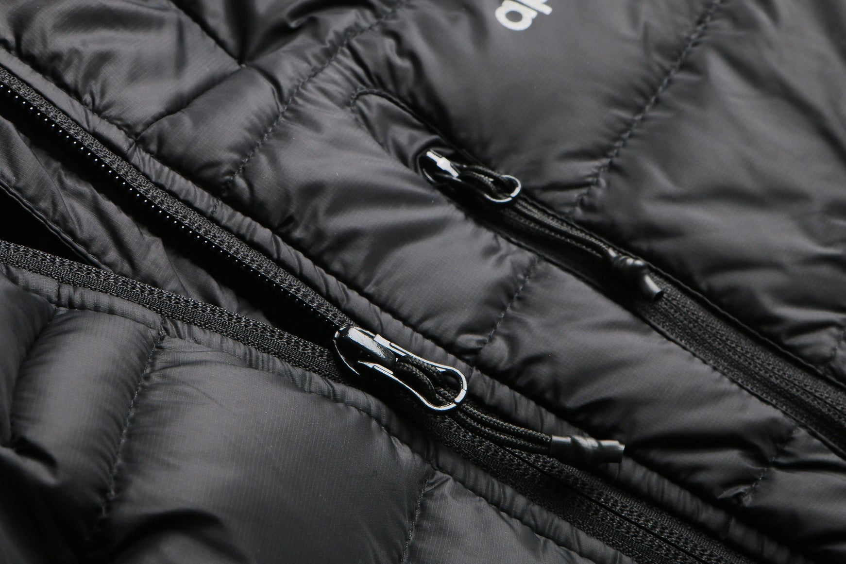 Close-up of a black puffer jacket with a zipper Aparso