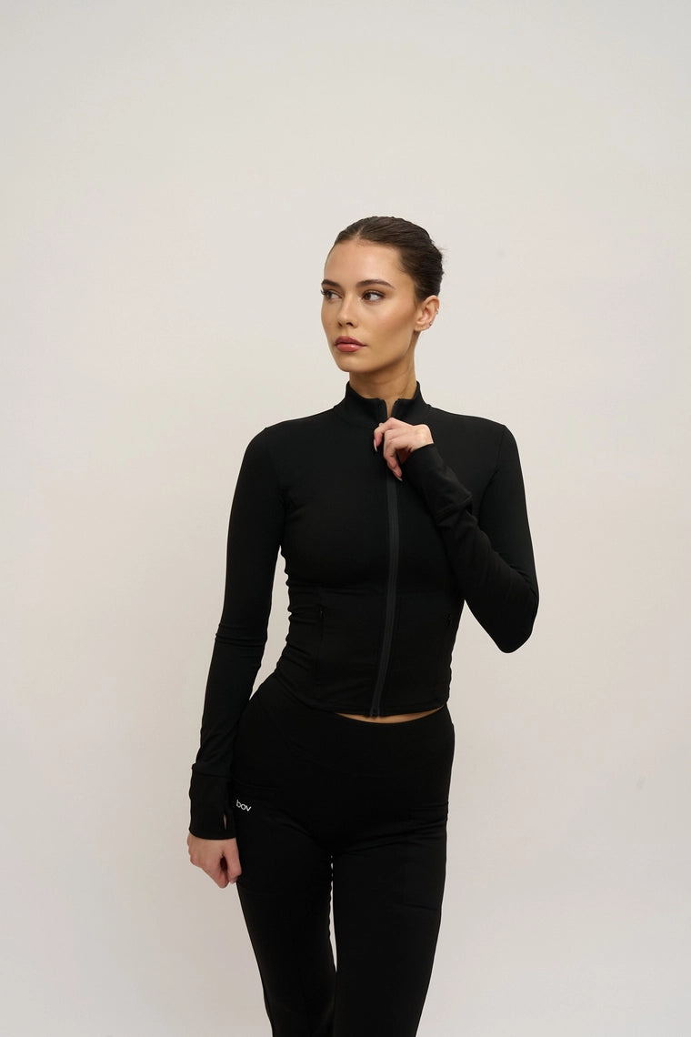 Woman wearing a black outfit against a plain background