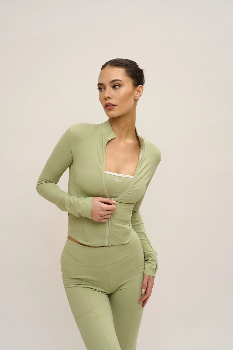 Woman wearing a green outfit on a plain background
