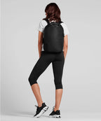 Person wearing a black backpack on a light gray background RYU