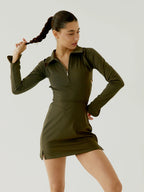 Woman wearing a BOV green dress against a plain background