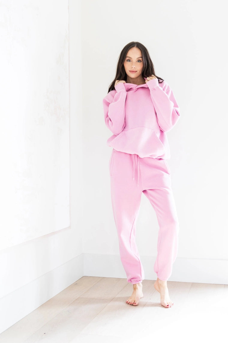 Woman wearing a pink tracksuit against a white background PRIV