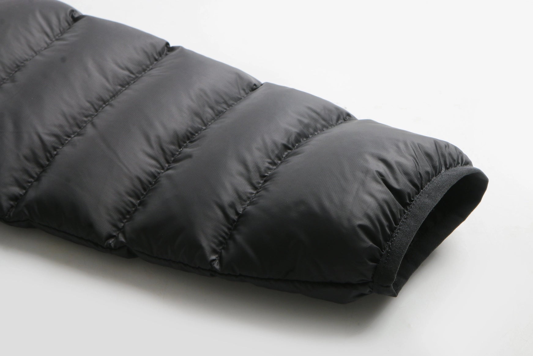 Black puffer jacket on a light gray background Aparso