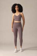 Woman wearing rose boreal brown outfit  on the floor against a beige background