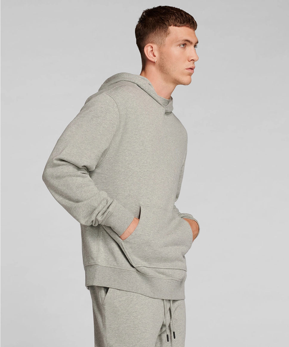 Man wearing a gray hoodie and pants on a light gray background RYU