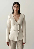 ANAZ Woman wearing a beige blazer and pants against a plain background