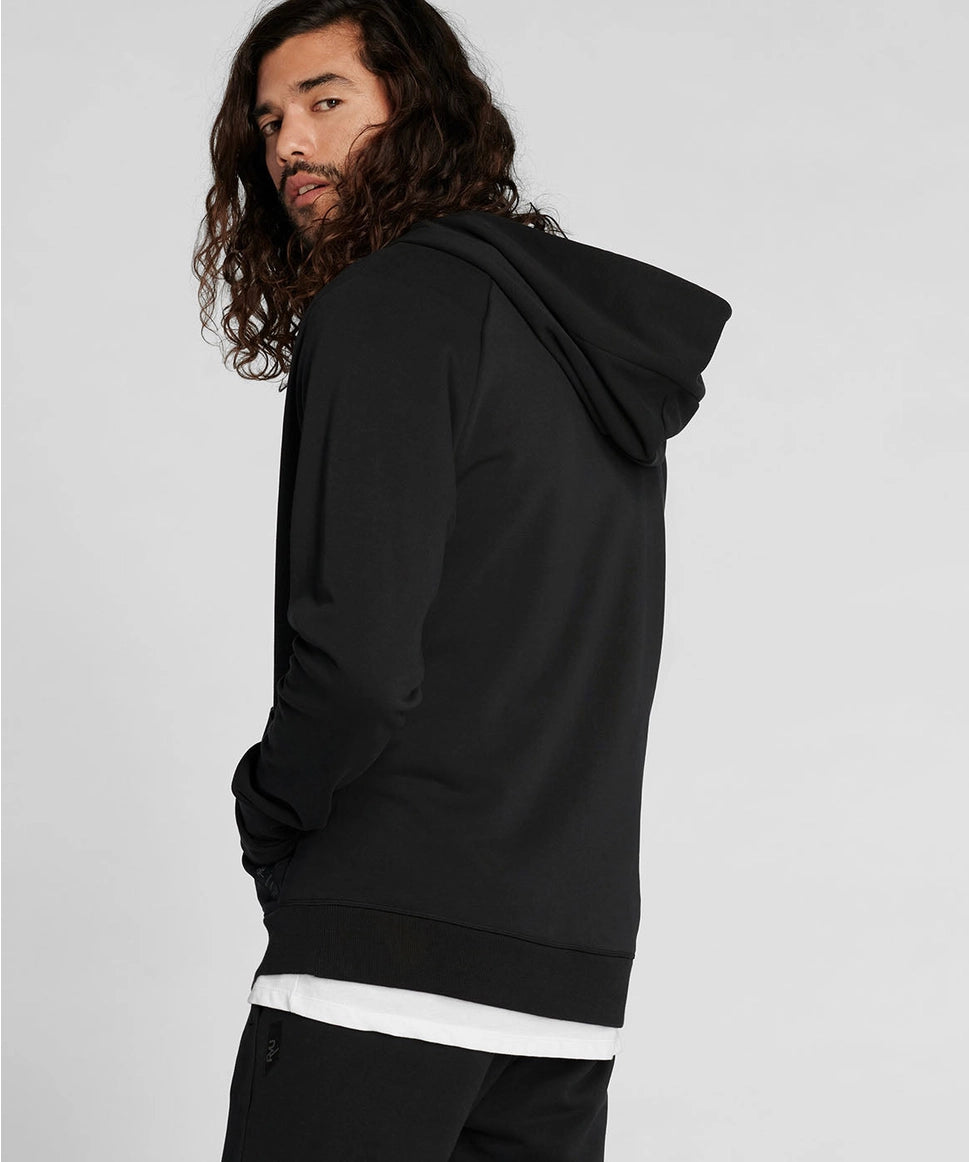 Man wearing a black hoodie on a plain background RYU