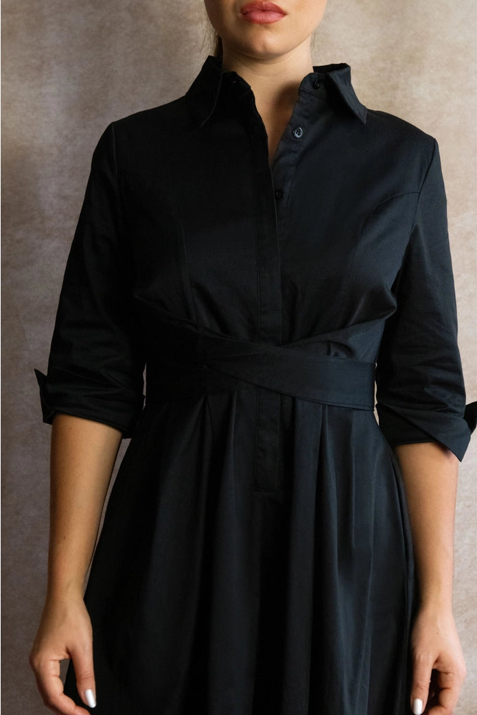 Black dress worn by a person against a neutral background ANNICK