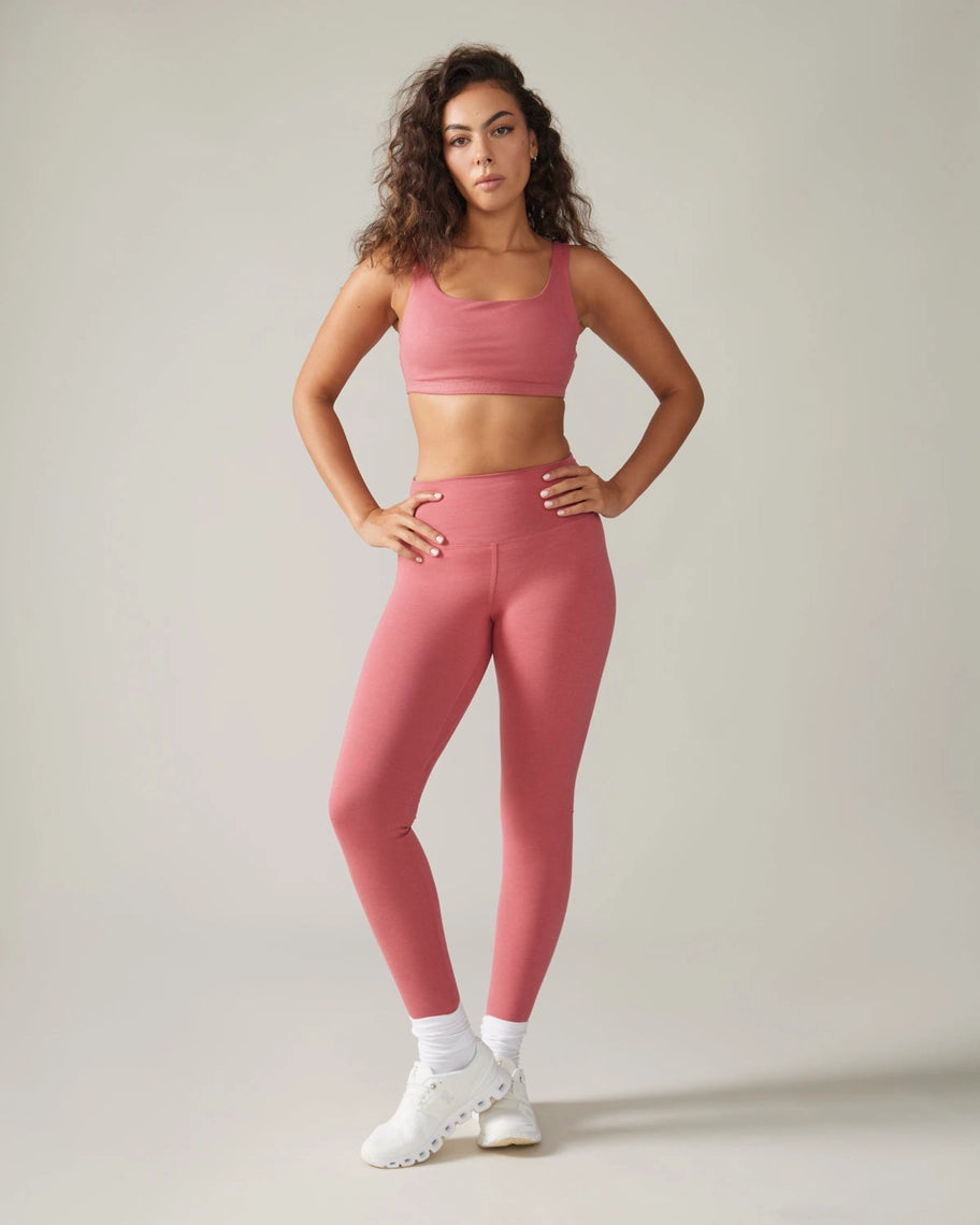 Woman wearing a pink athletic outfit on a plain background rose boreal