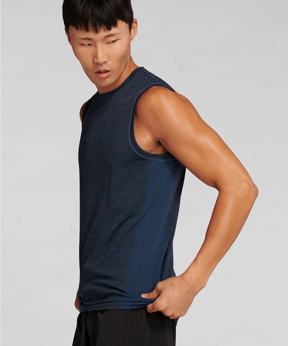 Man wearing a navy sleeveless shirt against a gray background RYU