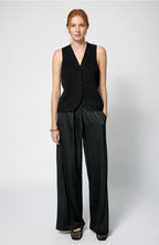 Woman wearing a black sleeveless top and wide-leg pants on a white background Amanda Maria  