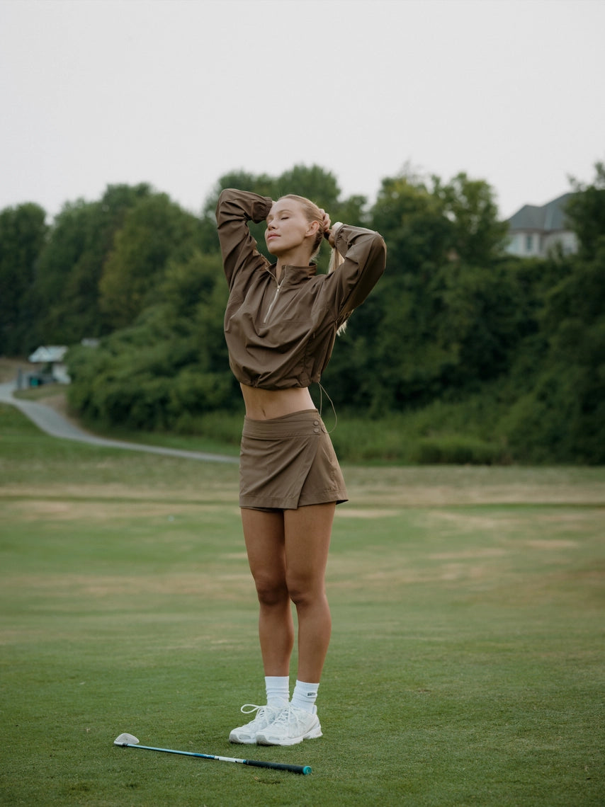 Woman holding a golf club on a golf course close out